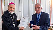 Bischof Gregor Maria Hanke überreicht die Bistumsmedaille in Silber an Karl Weber. 